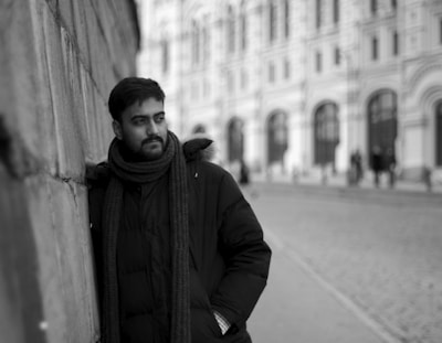 A sleek black and white photo showcasing a model wearing a Stone Island jacket against a minimalist urban backdrop.