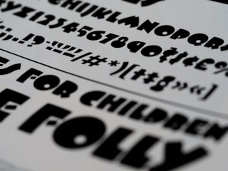 Minimalist black and white typography samples layered over textured paper.