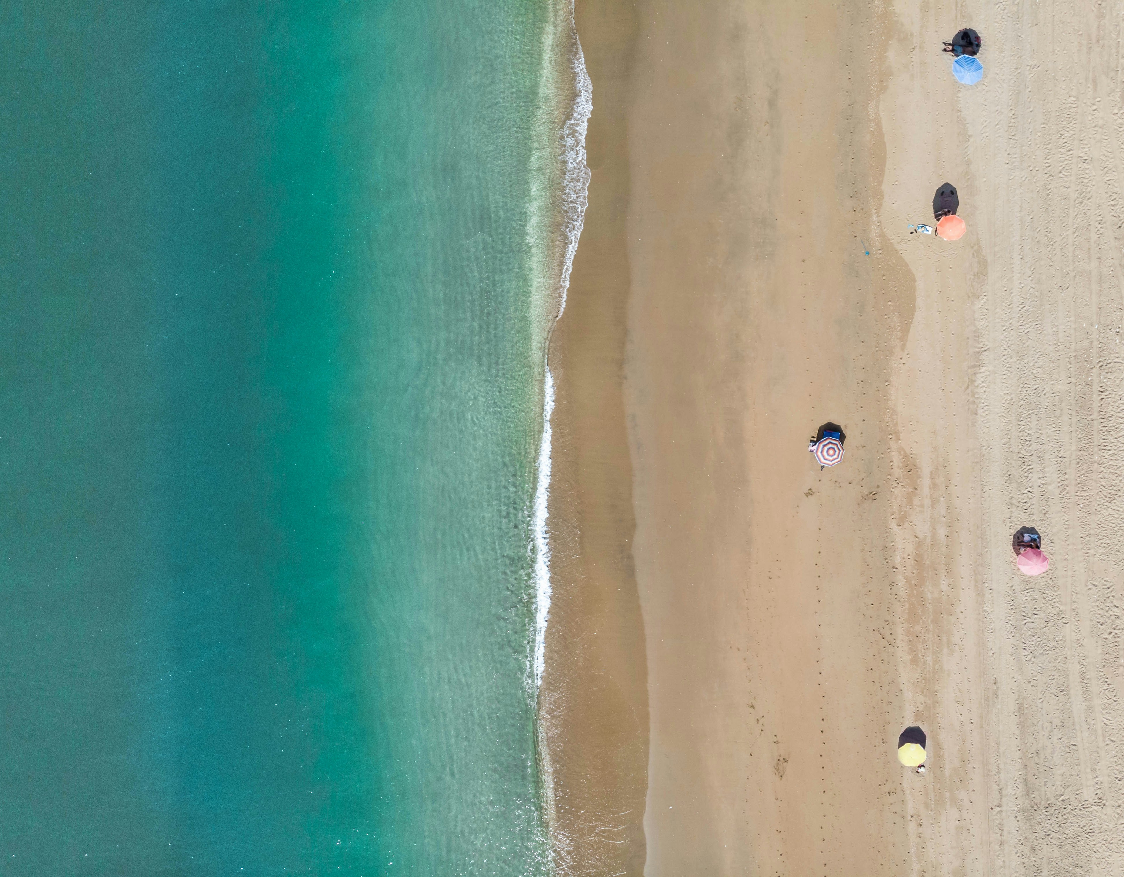 people on beach during daytime, Socially distancing at the beach
