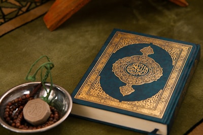 A pocket-sized Quran held in a hand for easy carrying.