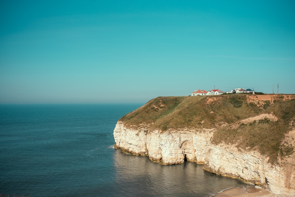 brown rock formation beside blue sea under blue sky during daytime