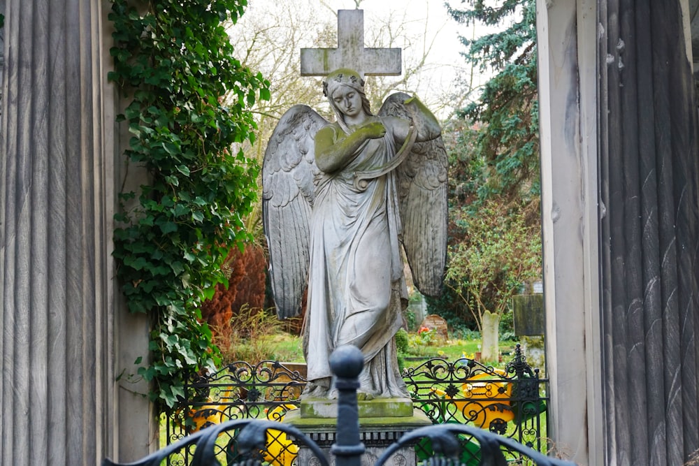 woman in dress statue near black metal fence