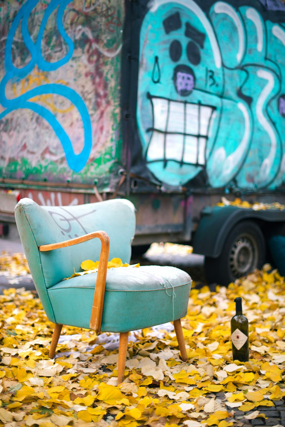 silla de madera amarilla y marrón junto a la pared de graffiti azul y blanco