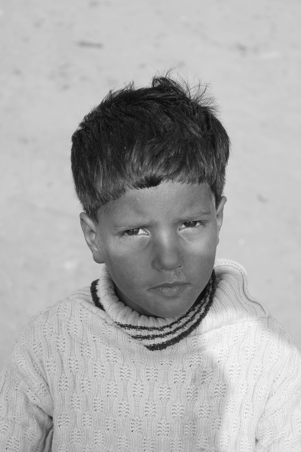 grayscale photo of boy in knit sweater