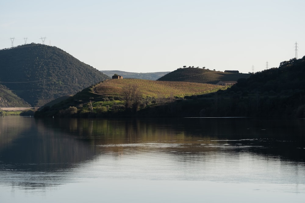 green and brown mountain beside body of water during daytime