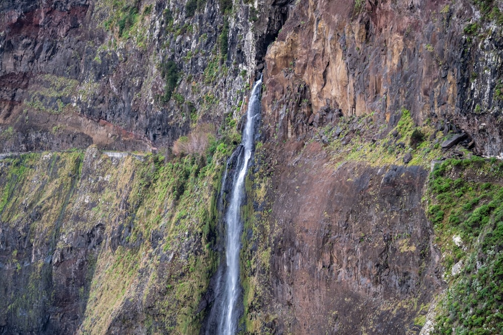 waterfalls on brown rocky mountain during daytime