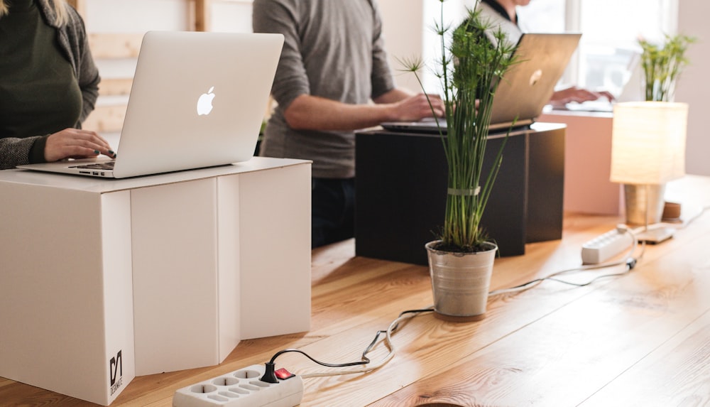 silver macbook on brown wooden table