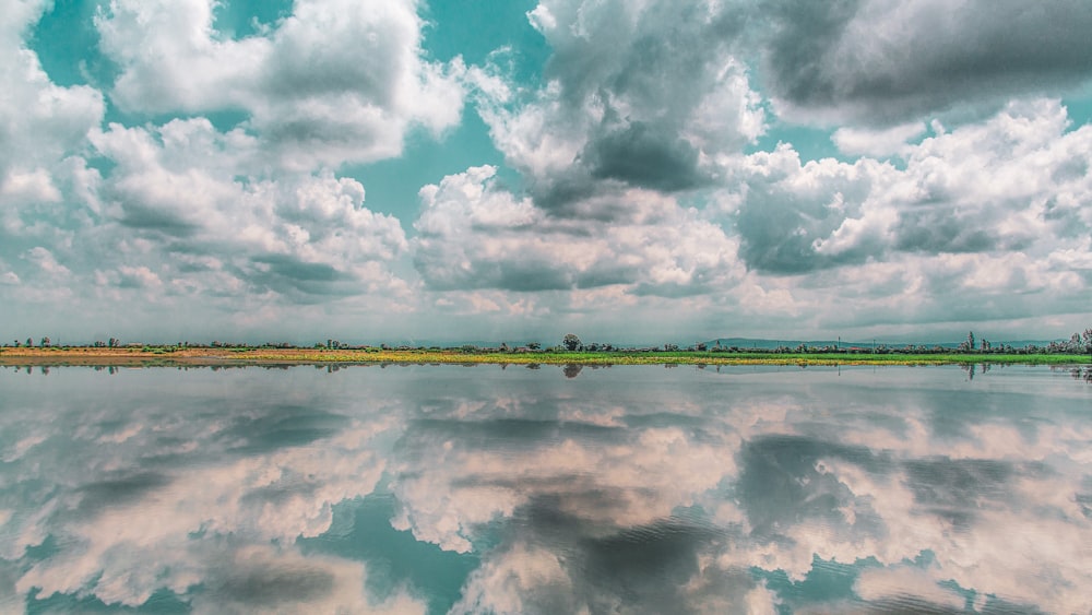 specchio d'acqua sotto il cielo nuvoloso durante il giorno