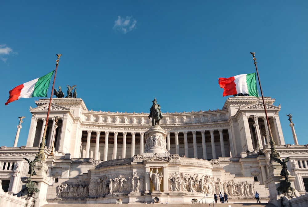 white concrete building with statue under blue sky during daytime