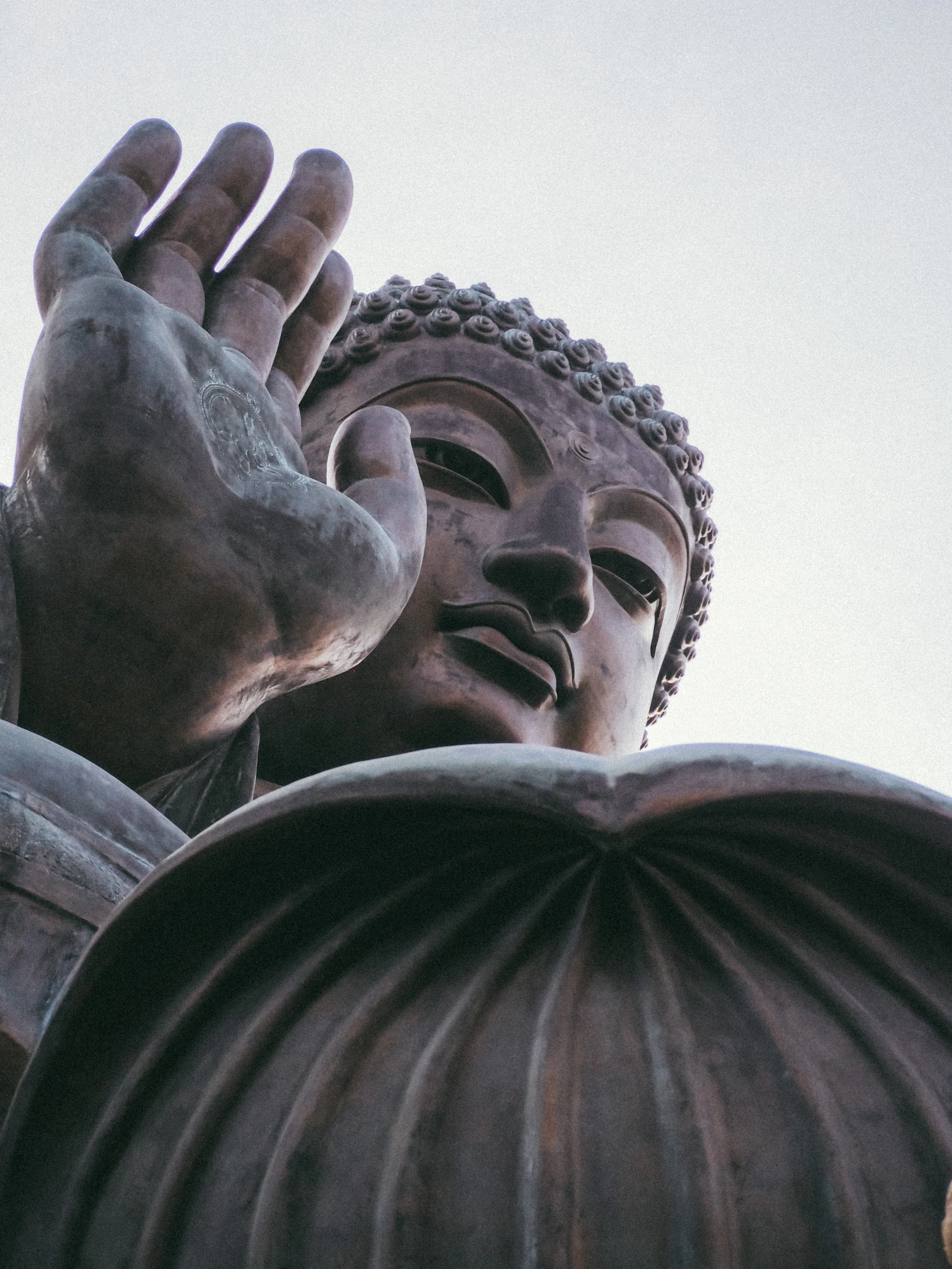 A close view of the Tian Tan Buddha's raised hand and face at Ngong Ping, Lantau Island.
