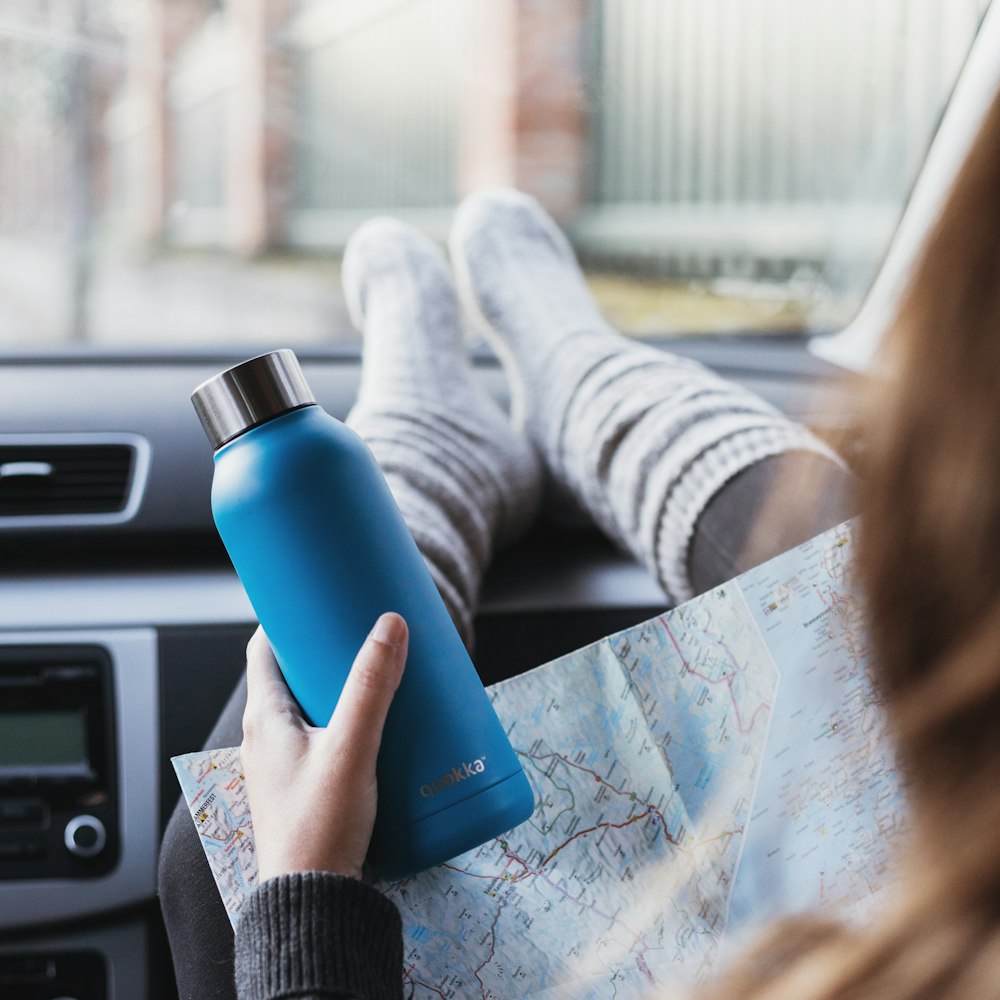 person holding blue and silver bottle