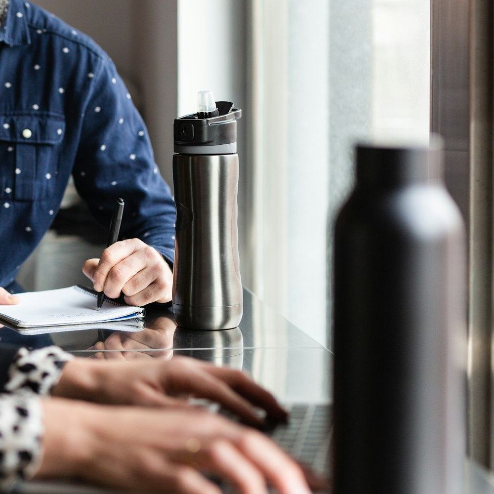 person in blue and white long sleeve shirt using macbook pro