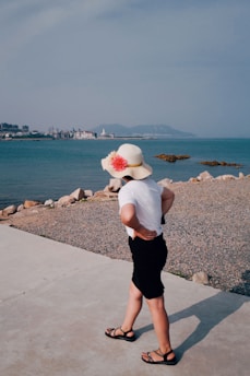 woman in white shirt and black skirt standing on gray concrete dock during daytime