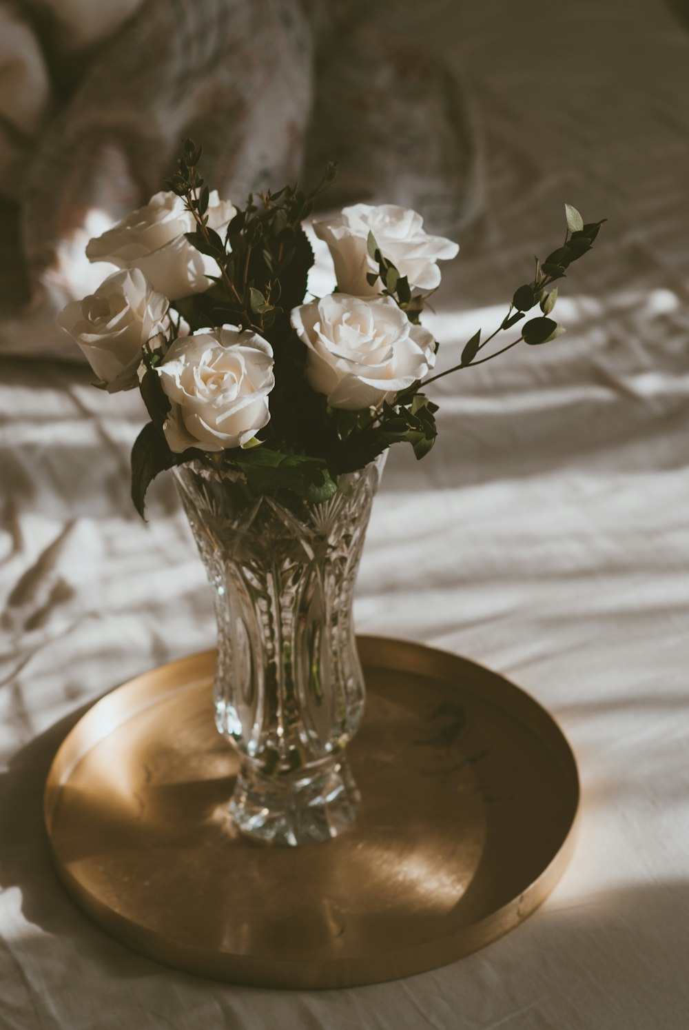 white roses in clear glass vase