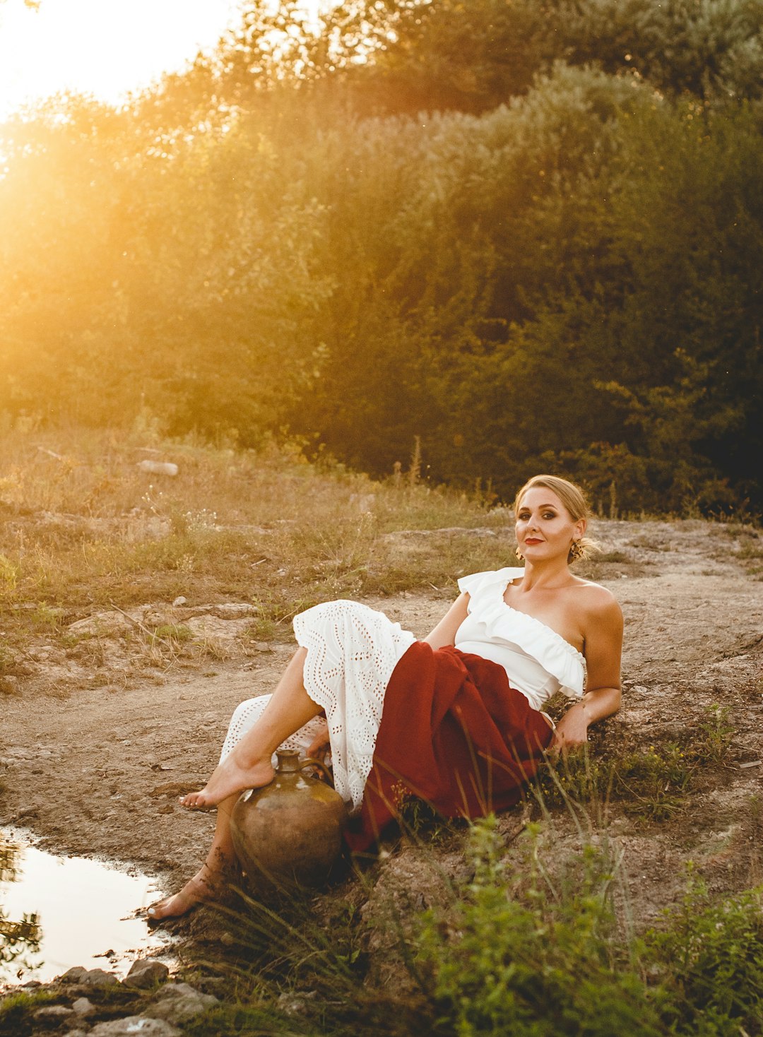 woman in white dress sitting on ground during daytime