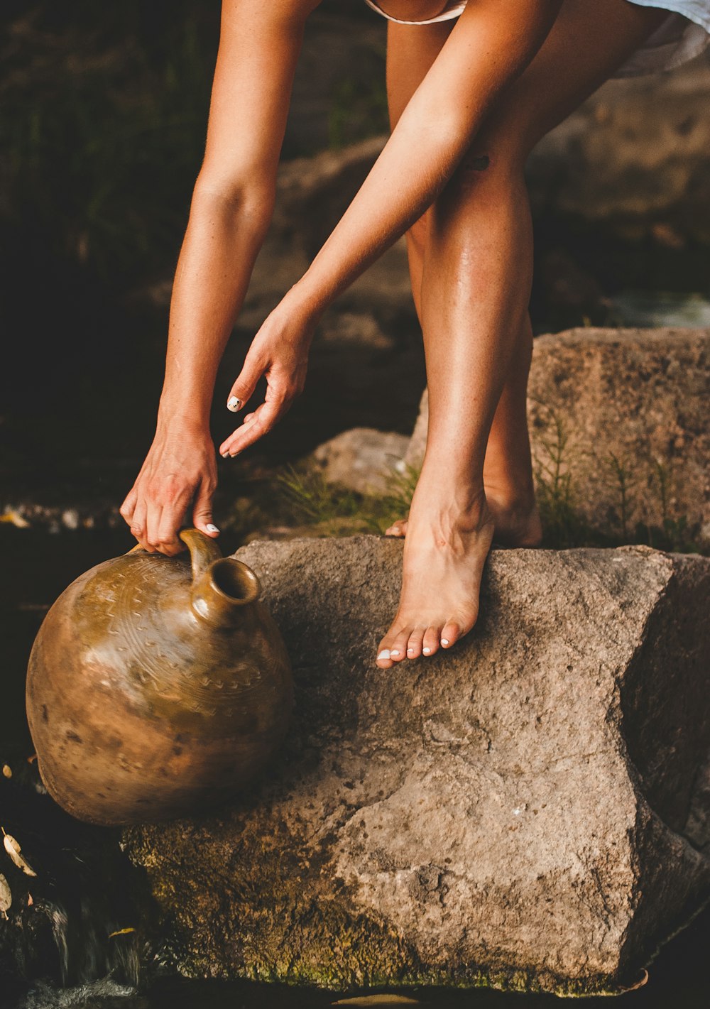 woman in black panty sitting on brown rock