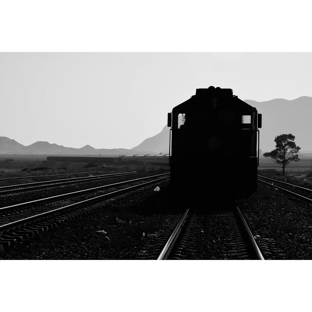 grayscale photo of train on rail tracks