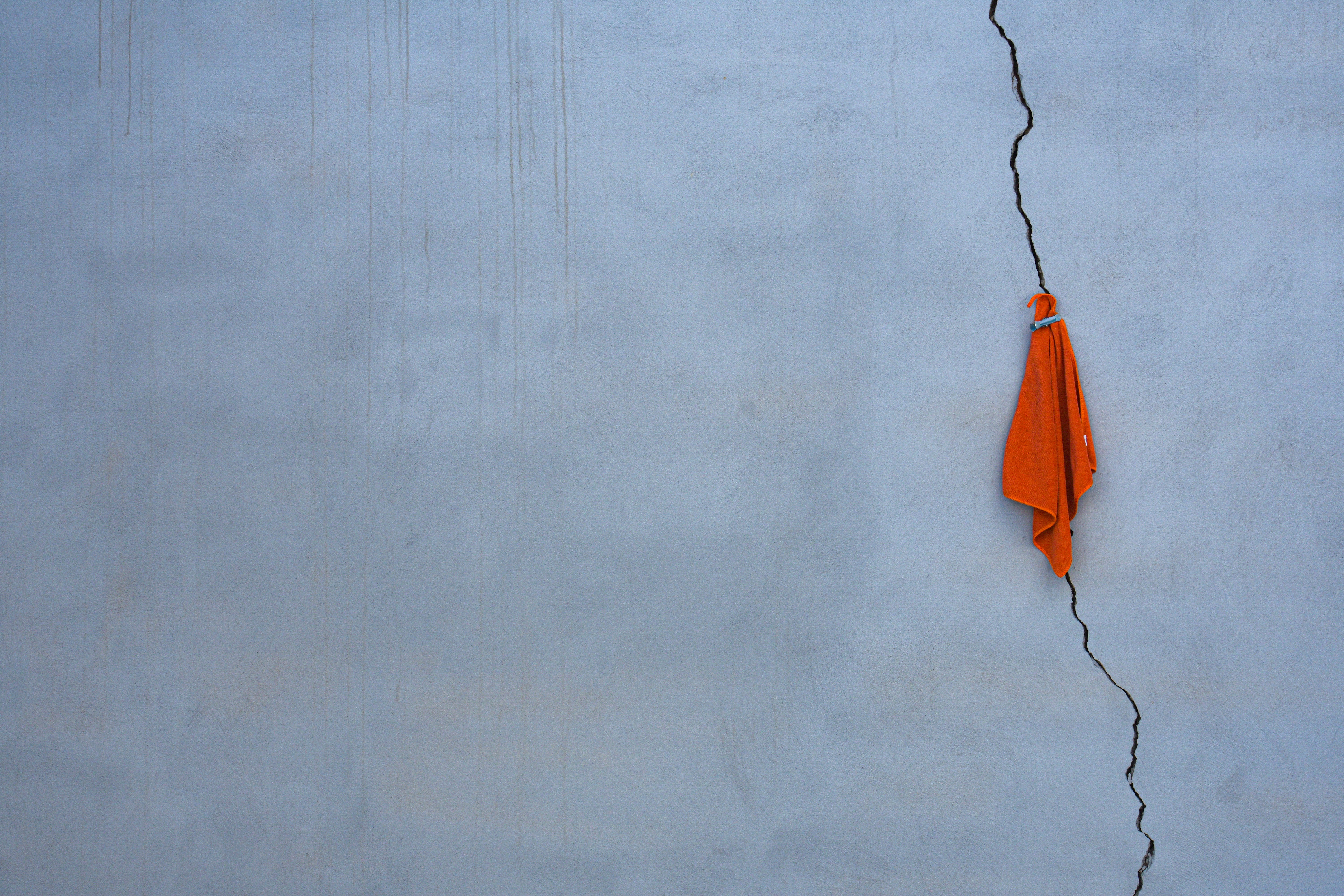 orange and yellow umbrella hanging on white wall