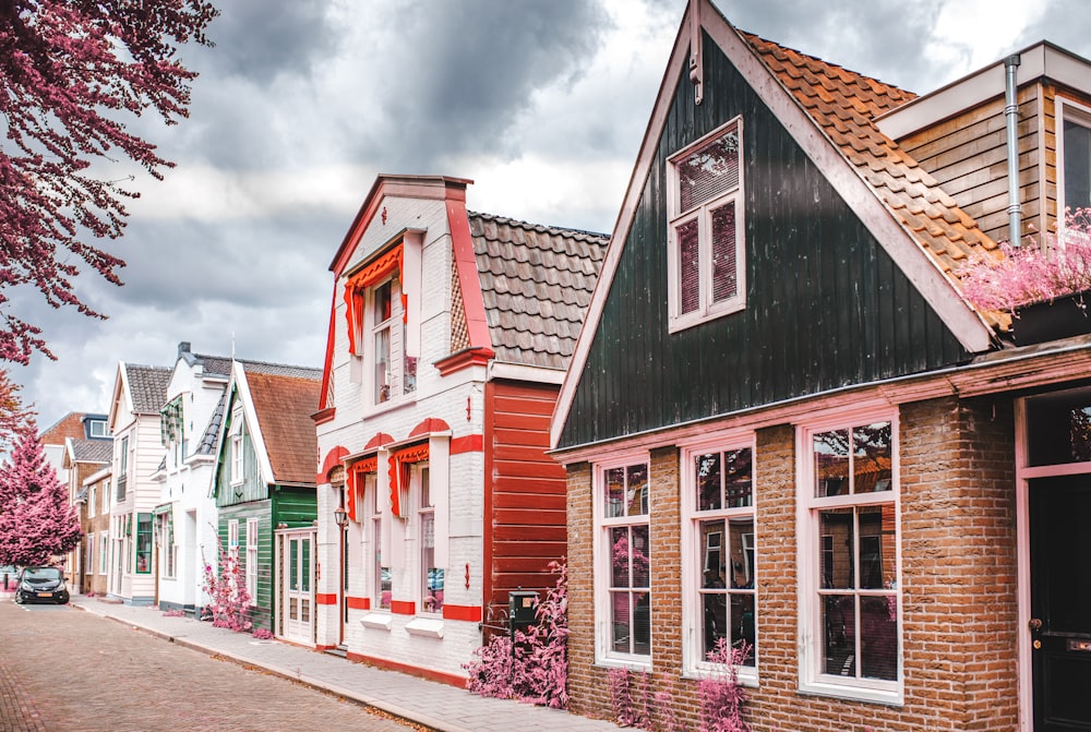 red white and black houses under white clouds during daytime