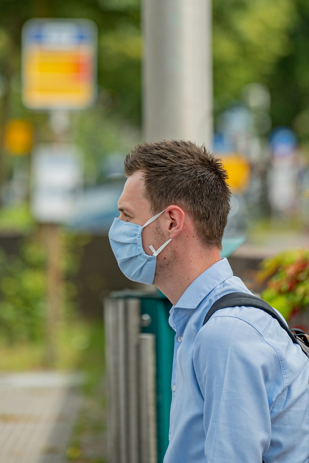 man in blue dress shirt wearing white earbuds