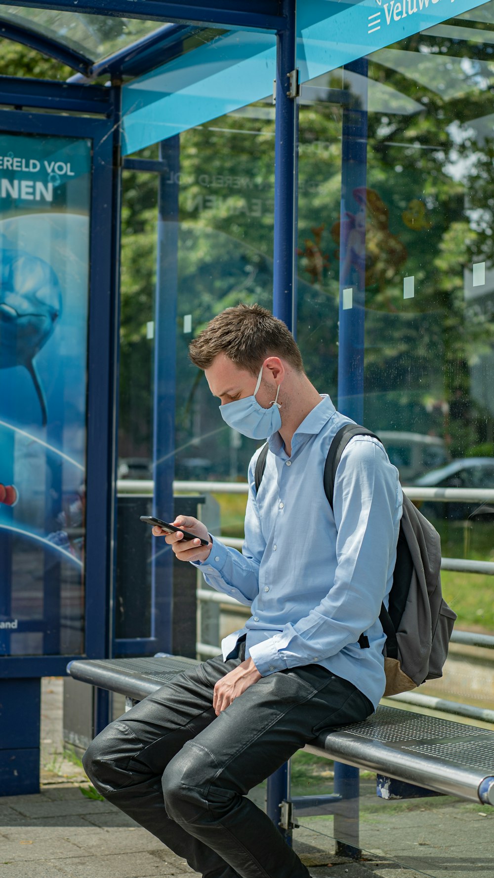 Uomo in camicia bianca e gilet nero usando lo smartphone