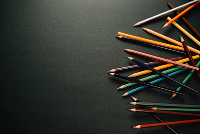 A colorful open coloring book with partially finished intricate patterns and vibrant pencils scattered around.