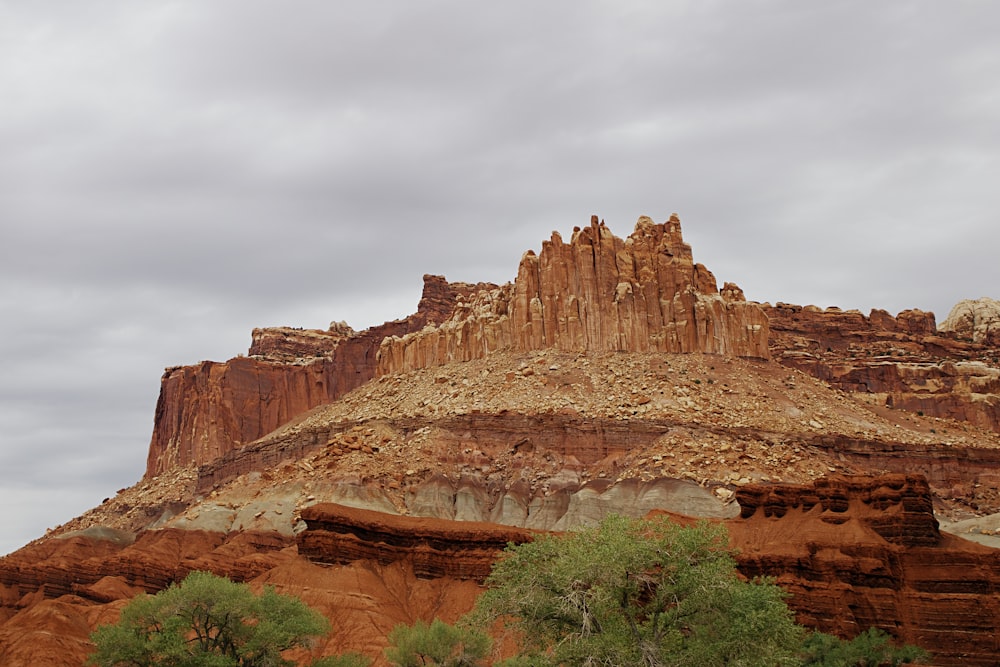 brown rock formation under white clouds during daytime