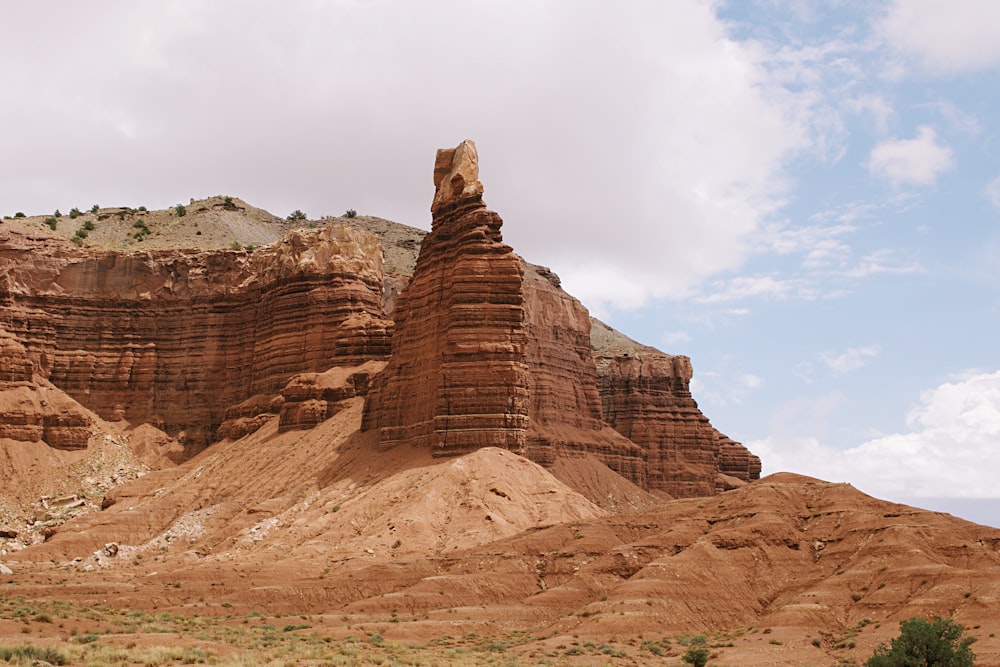 brown rock formation under white clouds during daytime