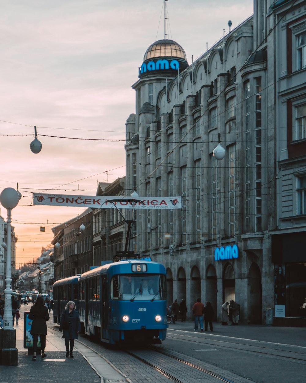 Tramway bleu et blanc sur la route près du bâtiment pendant la journée