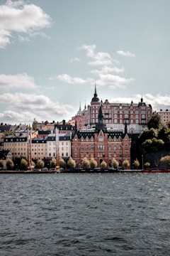 white and brown concrete building near body of water during daytime
