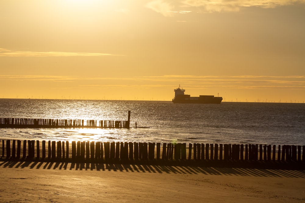 silhouette of ship on sea during sunset