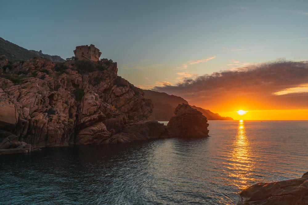 Braune Felsformation auf dem Meer bei Sonnenuntergang