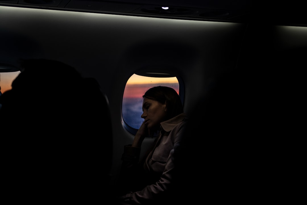 man in gray jacket sitting on airplane seat