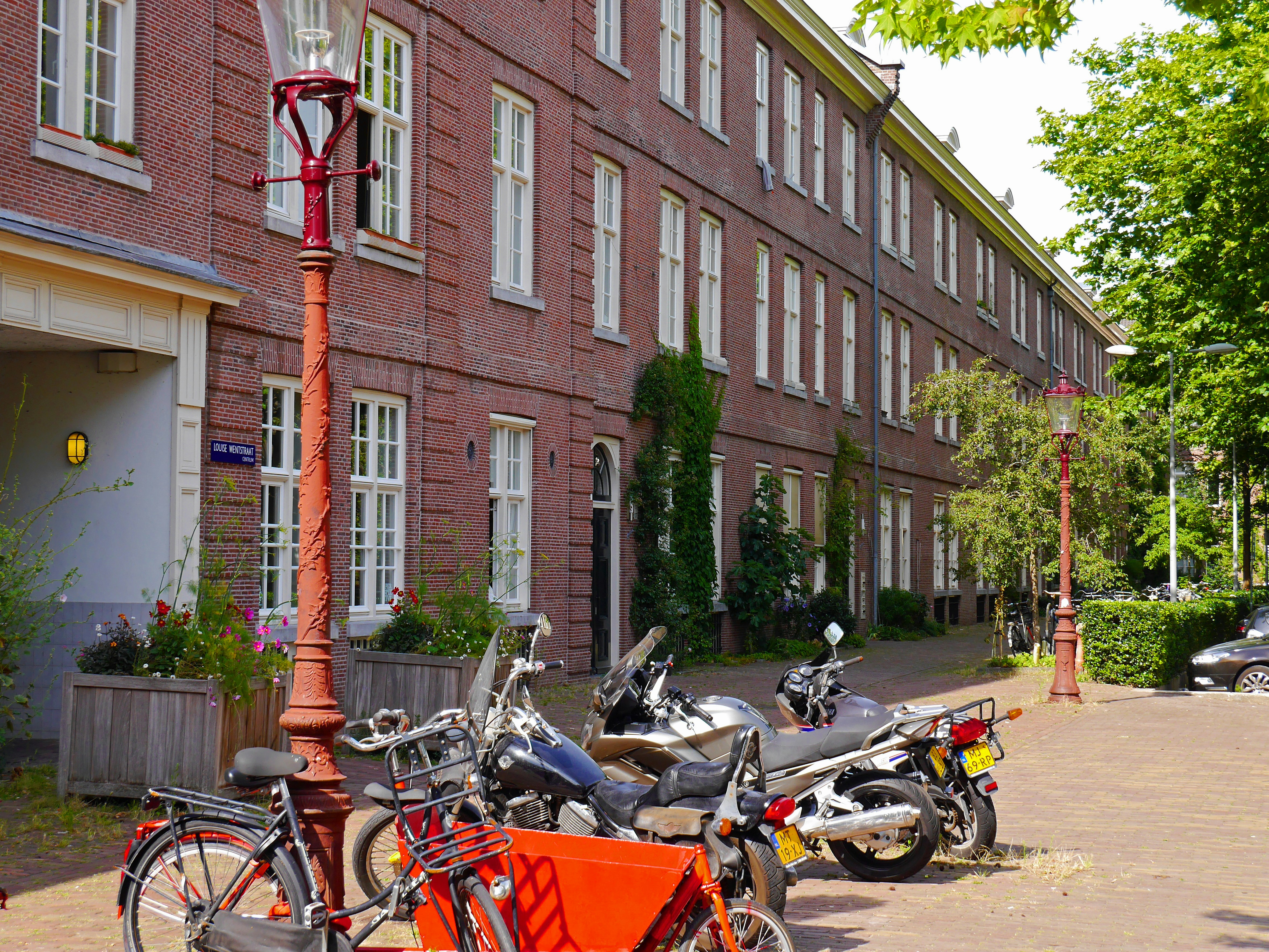 A view along the brick old back-facade of a historical barrack-building in the city Amsterdam, Dutch old architecture of a historical place. Free photo of July 2020 by Fons Heijnsbroek, Netherlands. Nederlands: een kijkje langs de bakstenen achtergevel van de binnenkant van de oude Oranje Nassaukazerne - een historisch gebouw in hollandse oude architectuur - van Amsterdam is het de langste gevel in de stad. Gratis foto van Fons Heijnsbroek, Nederland.