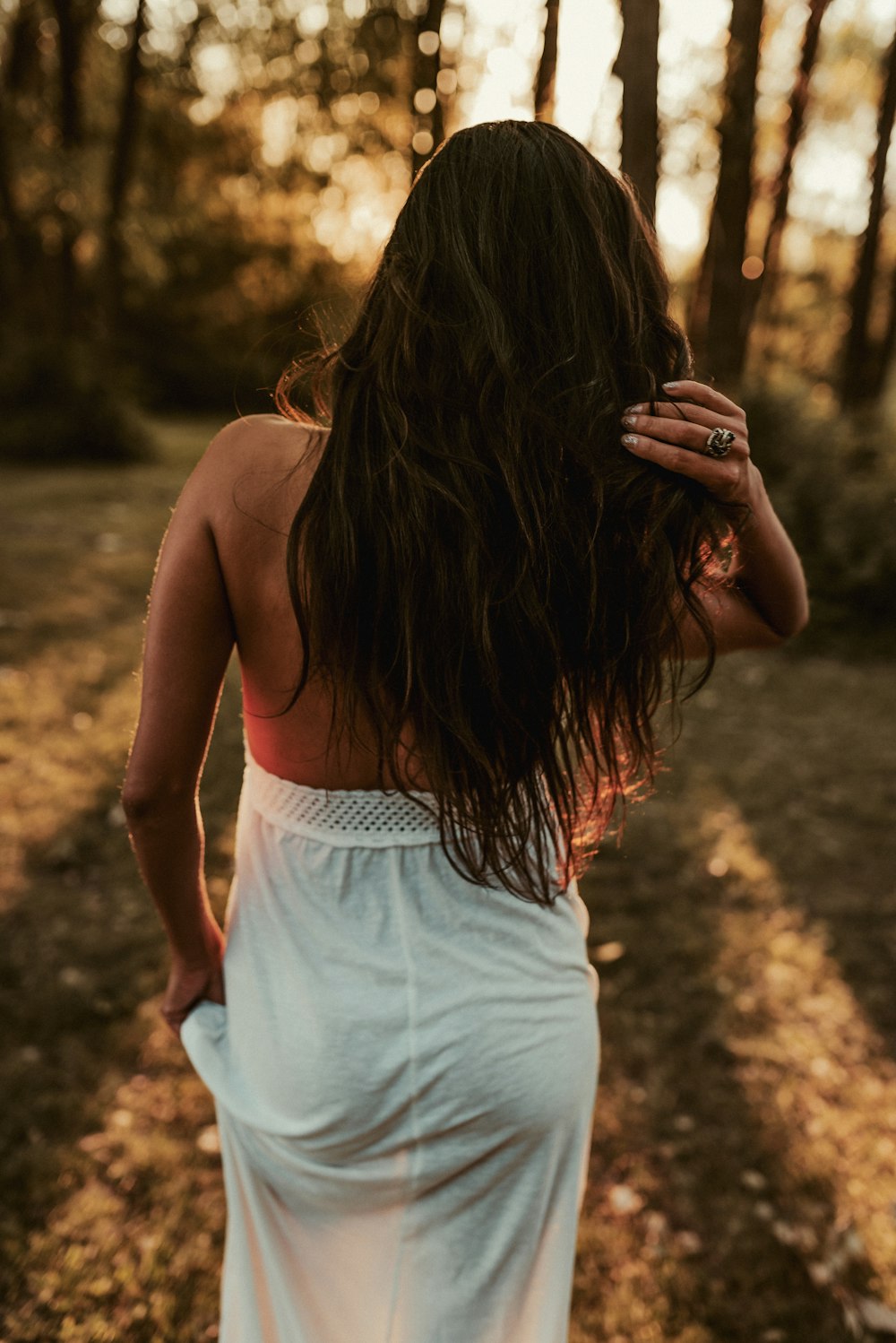 woman in white tank top and white shorts standing on brown soil during daytime