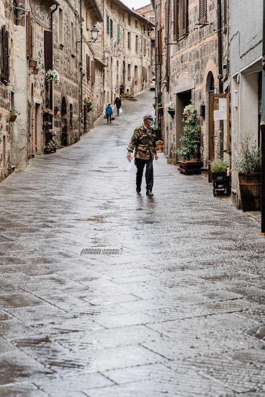 man in green jacket walking on street during daytime in Radicofani Italy