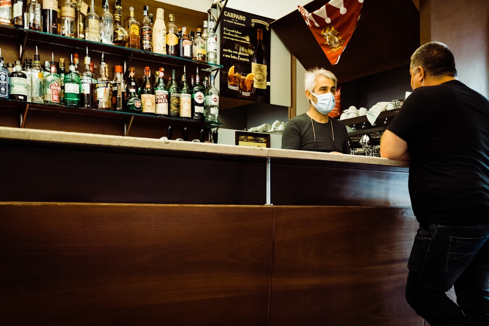 mujer con camisa negra sentada en la barra del bar