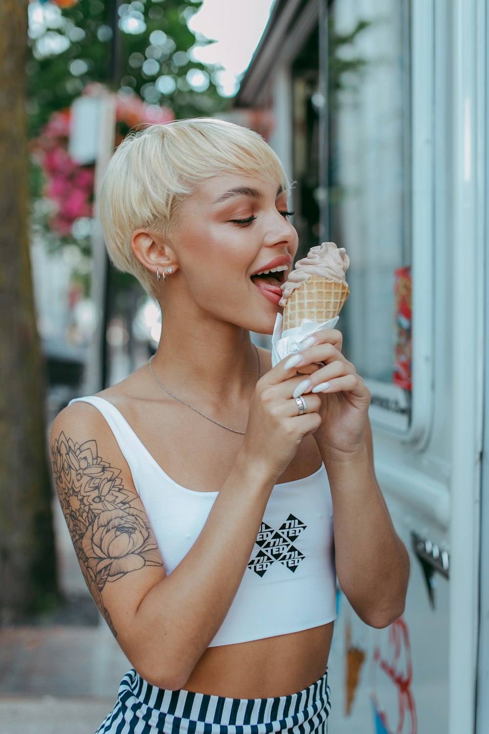 mujer en camiseta blanca sosteniendo cono de helado