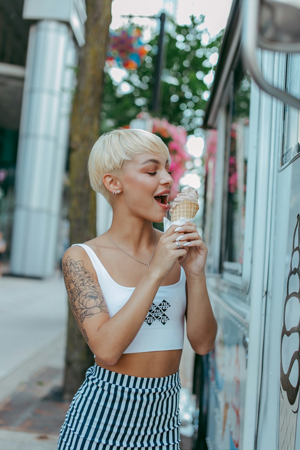 Mujer en camiseta blanca sin mangas sosteniendo cono de helado