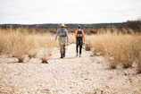 Guide helping a guest with fly fishing gear on the riverbank surrounded by desert landscape