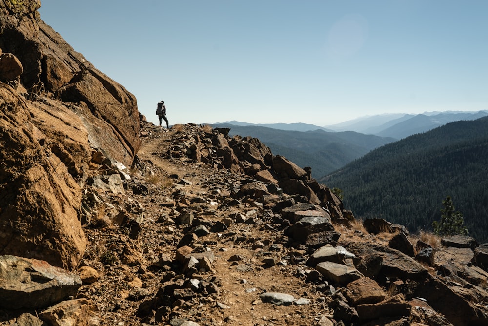 person standing on rocky hill during daytime