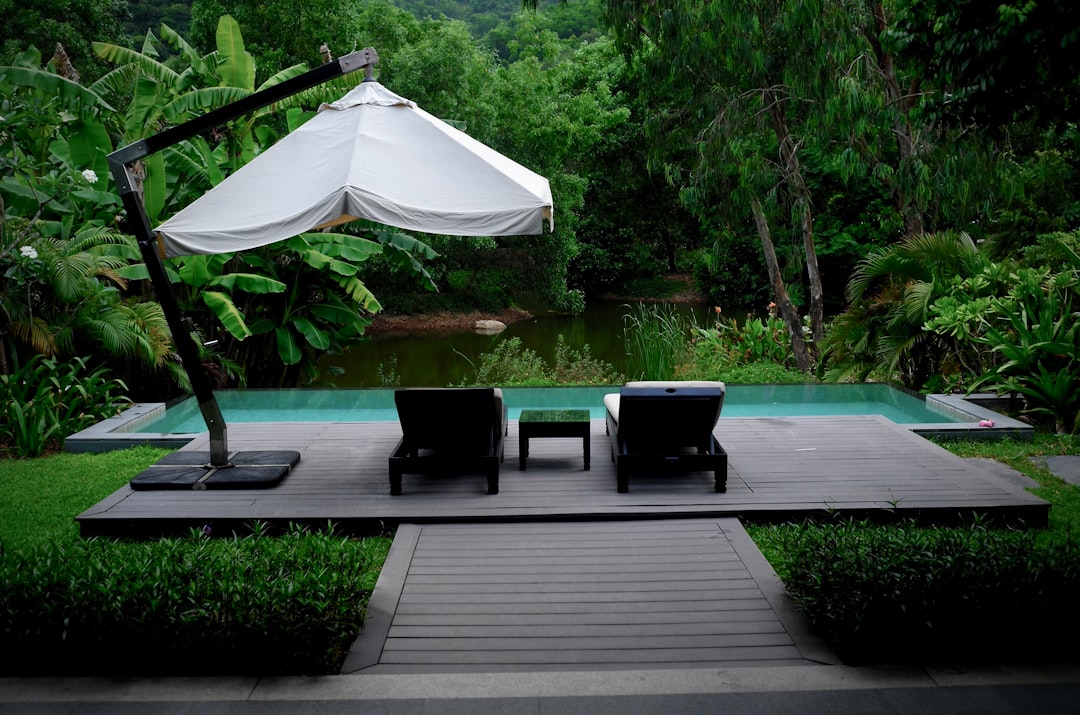 white patio umbrella near swimming pool