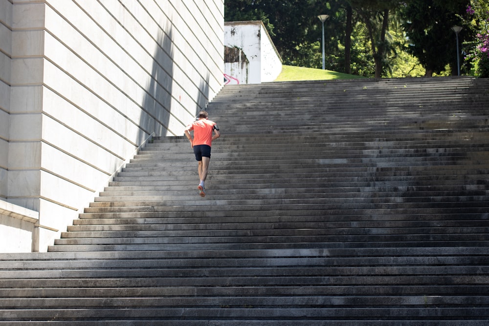 girl in pink shirt and blue shorts walking on wooden pathway