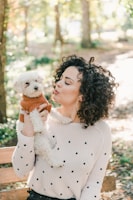 woman in white sweater holding white bear plush toy
