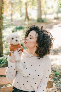 woman in white sweater holding white bear plush toy