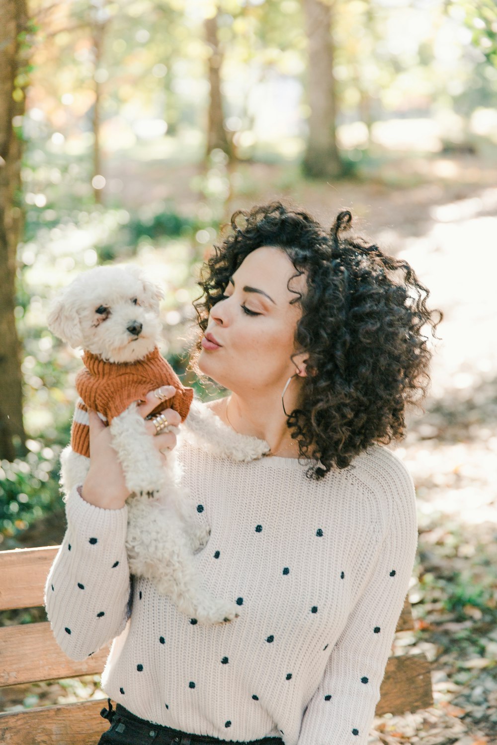 woman in white sweater holding white bear plush toy