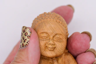 A small thumbnail of a wooden carved figurine with its name below.