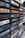 A close-up view of a collection of vintage music cassette tapes stacked together, featuring a variety of artists and music genres. The spines of the cassette cases display the names of musicians and albums in bold, colorful fonts.