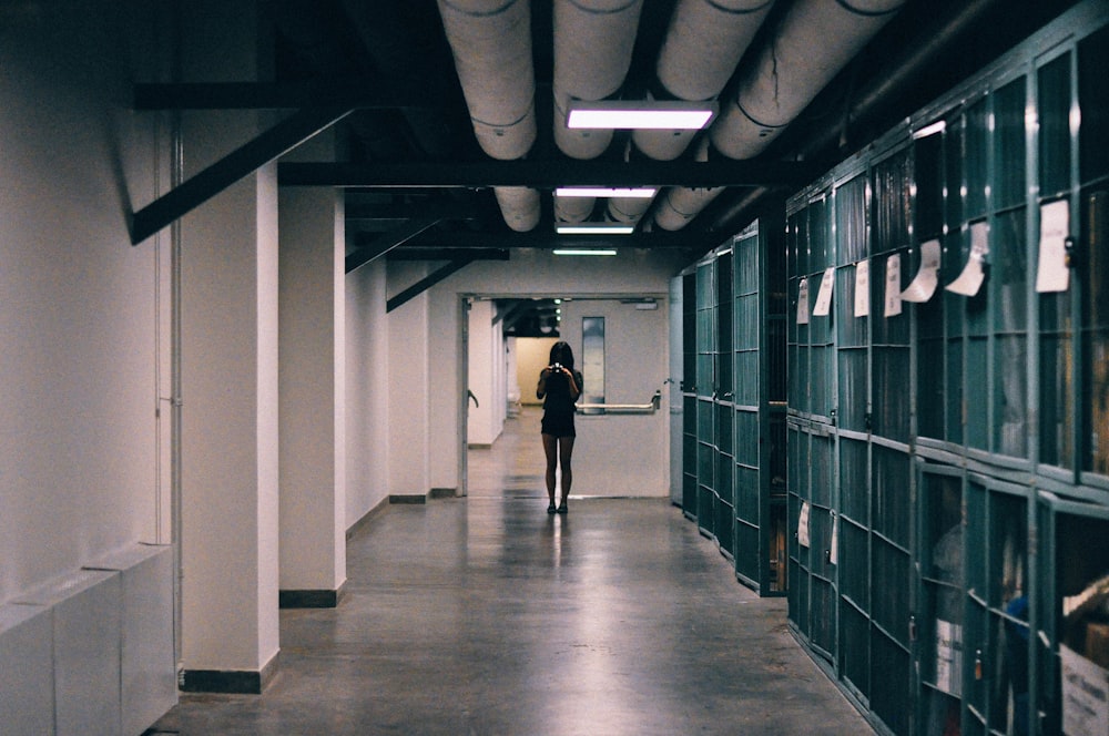 man in black jacket walking on hallway