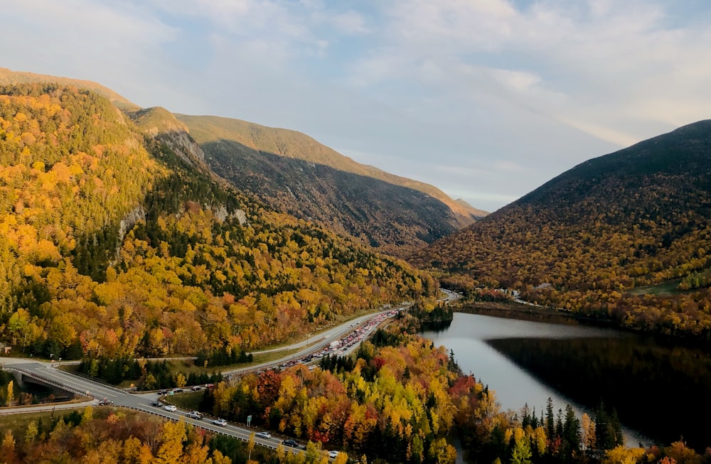 Montañas verdes y marrones junto al río durante el día